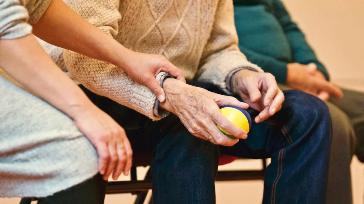 Caregiver holding hands of an elderly person providing compassionate support