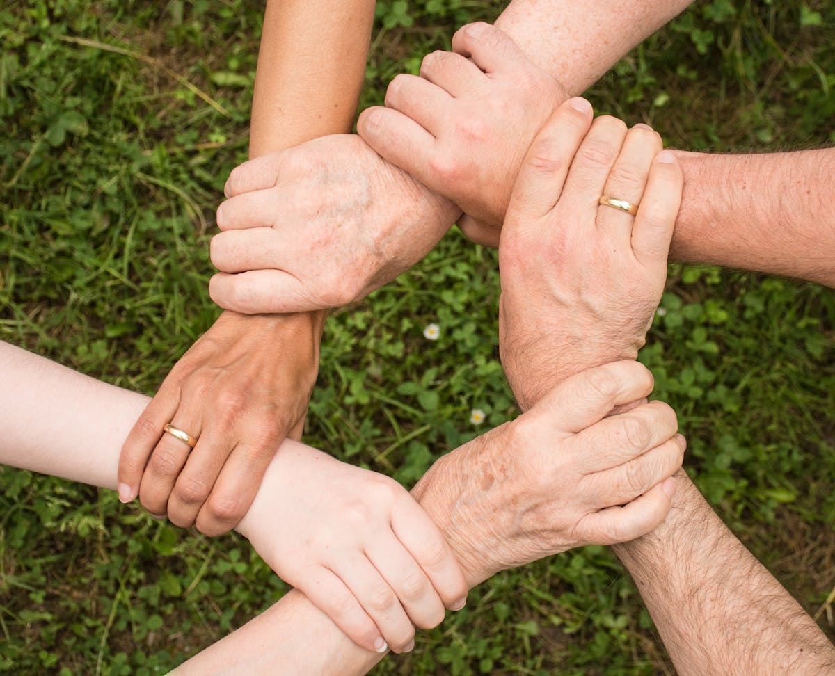 People holding hands together in community support - Quinte Organ Transplant Support Group