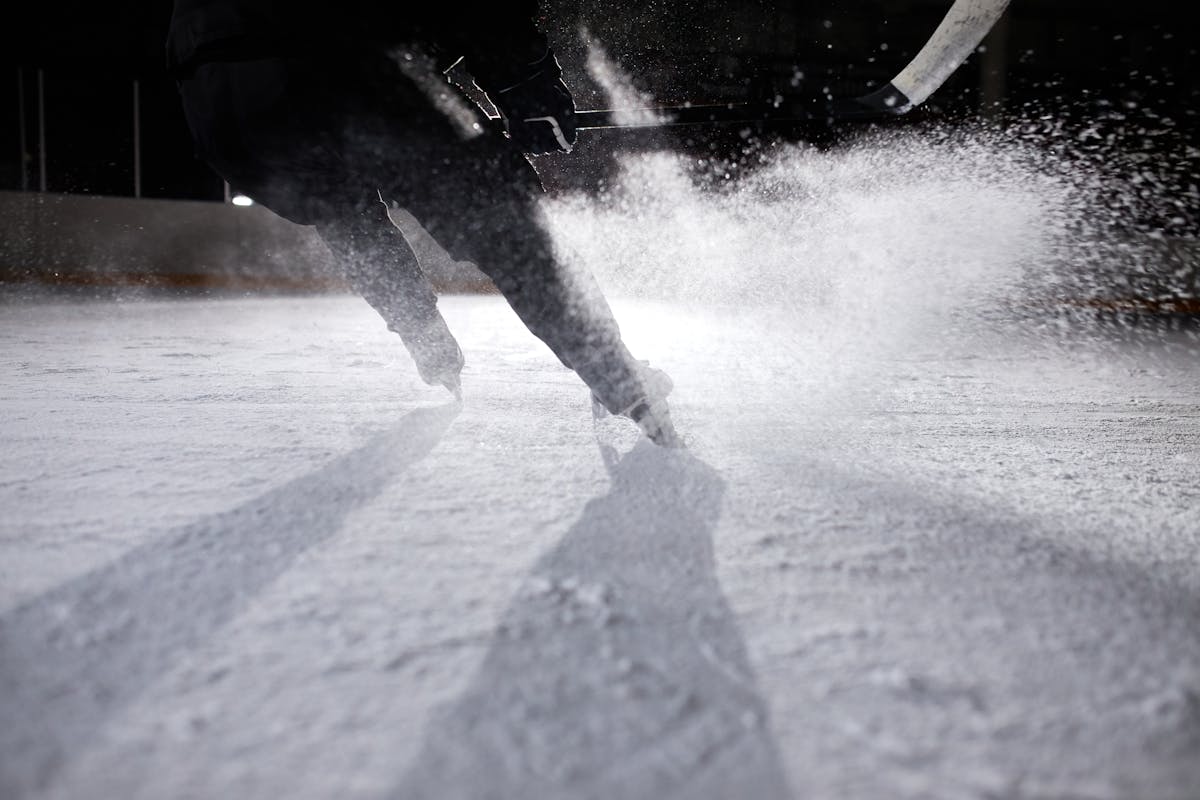 Ice hockey player creating dramatic ice spray during fast skating - AHL All-Star hardest shot Belleville Senators